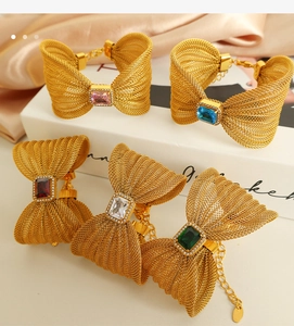 Detail of elegant gold woven mesh bow bracelets with colorful square gemstones