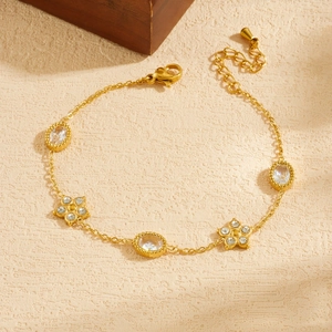 Gold-plated stainless steel bracelet with oval crystals and five-petal flower charms