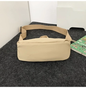Minimalist beige nylon crossbody bag with adjustable wide strap and smooth texture