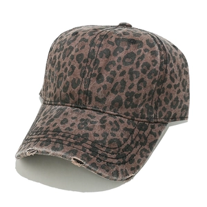 Close-up of leopard print baseball cap featuring distressed edges and washed cotton texture
