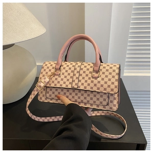 Detailed shot of pink crossbody bag with geometric prints and gold-tone hardware detail
