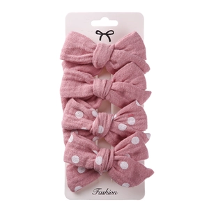 Detailed view of 4-pack pink fabric hair bows with polka dots on display card