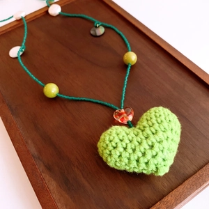 Vue macro du pendentif cœur en peluche tissé main avec perles et accents de perles fins