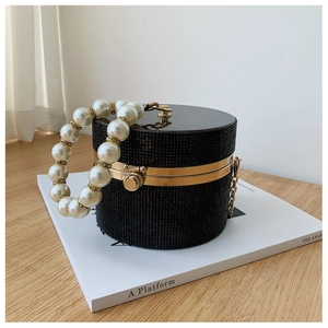 Detail of black cylindrical party bag with sparkling crystals and pearl handle