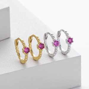 Detail of S925 sterling silver hoop earrings with round rose red gemstone inlays