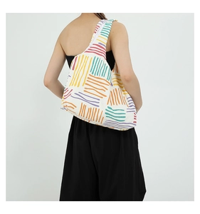 Close-up of a white tote bag featuring vibrant colorful wavy patterns and soft fabric texture