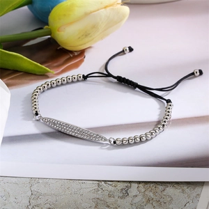 Détail macro du bracelet cœur croix avec perles argentées et breloque en cristal scintillant