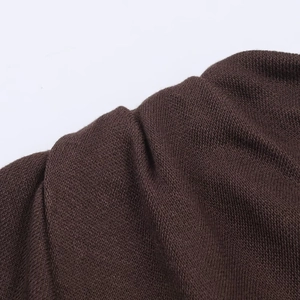Macro shot of dark brown knitted fabric texture showing fine textile detail and fibers