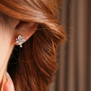 Gros plan d'une boucle d'oreille papillon en argent avec zircone sur un modèle