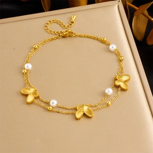 Detail of gold double-layer butterfly anklet with pearls on a decorative gift box
