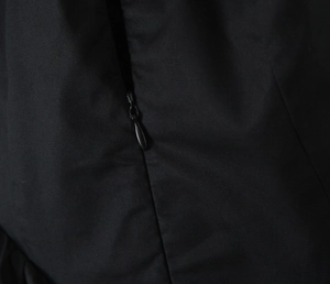 Close-up of the concealed black zipper and high-quality stitching on a woven black dress