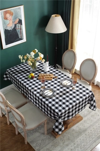 Top view of a black and white checkered cotton linen tablecloth on a six-person dining table