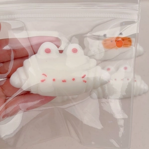 Close-up of cute white resin cloud charms for DIY accessories in transparent packaging