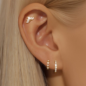 Close-up of gold S925 silver ear cuff and hoop earrings with sparkling marquise zircons