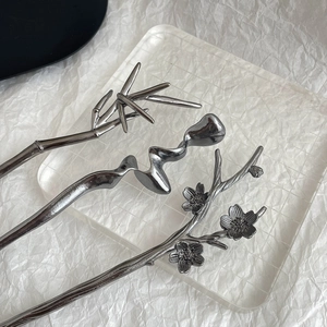 Detailed close-up of vintage metallic hair sticks in bamboo, wave, and plum blossom styles