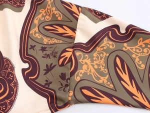Detailed macro view of woven fabric with beige and green paisley floral patterns