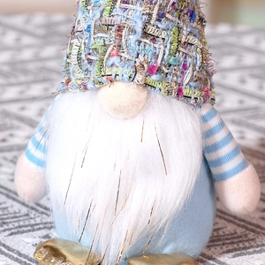 Gros plan d'un gnome de Noël avec longue barbe en peluche et bonnet en tricot coloré