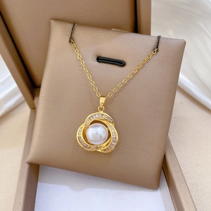 Macro shot of gold bird nest necklace with pearl and shimmering pavé zircons