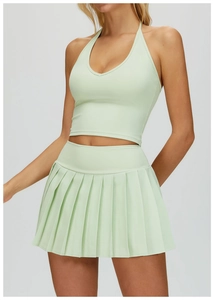 Vue détaillée du haut de yoga licou vert menthe et de la jupe plissée sur un mannequin