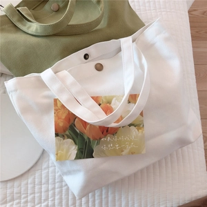Top view of white and olive green canvas mini tote bags with magnetic metal closures