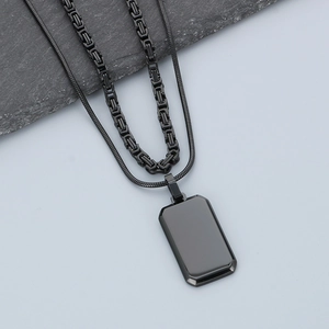 Detail of double-layer men's stainless steel necklace with black rectangular pendant