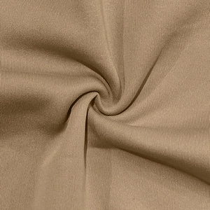 Macro shot of khaki ribbed knit fabric showing soft texture and fleece thickness on the jacket
