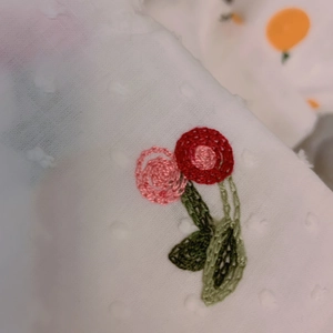 Close-up of Japanese style fabric with 3D white dots and floral embroidery details