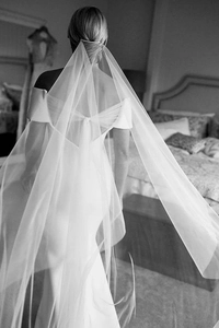 Artistic black and white detail of long sheer tulle wedding veil on elegant bridal gown