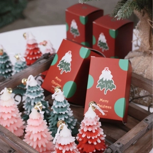 Christmas tree scented candles in red, green, and pink with festive gift box packaging
