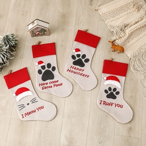 Set of four beige and red cat and dog paw Christmas stockings with pet-themed holiday quotes