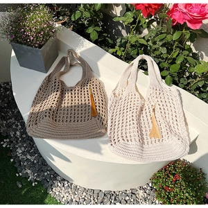 Close-up of woven cotton tote bags in khaki and beige with fringe tassel details