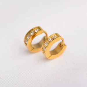 Macro shot of gold hoop earrings with clear zircon stones and a hinged closure