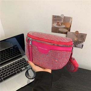 Pink rhinestone saddle bag with striped strap and mini coin purse in a lifestyle setting