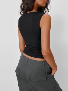 Dettaglio del top nero senza maniche aderente e dei pantaloni cargo multitasche