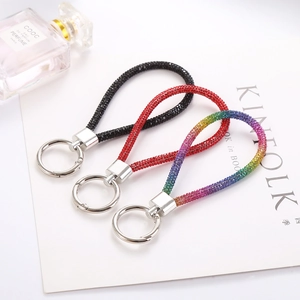 Detailed view of three luxury sparkling rhinestone keychains in black, red and rainbow colors