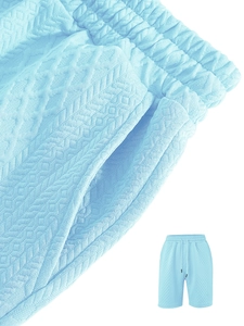 Detail of light blue jacquard shorts with elastic waist and unique geometric texture