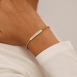 Elegant gold stainless steel bracelet with a crystal-encrusted bar on a delicate mesh chain