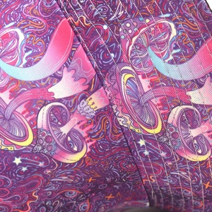 Detailed close-up of vibrant magic mushroom pattern and fine stitching on the bucket hat