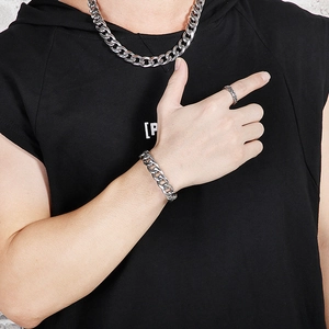 Detail showing men's silver Cuban link necklace and matching bracelet set on model
