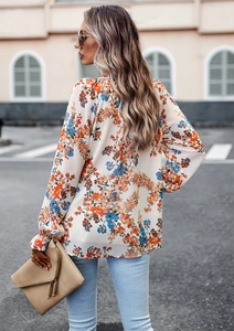 Vista street style di una camicia in chiffon floreale con eleganti motivi arancio e blu