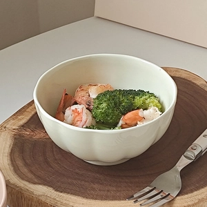Close-up of ceramic petal-edge bowl with shrimp and broccoli on wooden plate