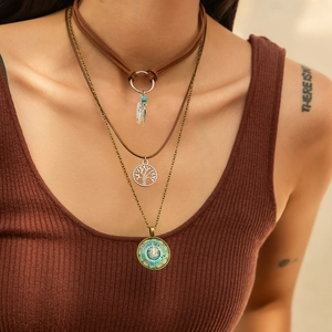 Detail of bohemian layered necklace set featuring bronze tree of life and mandala pendants