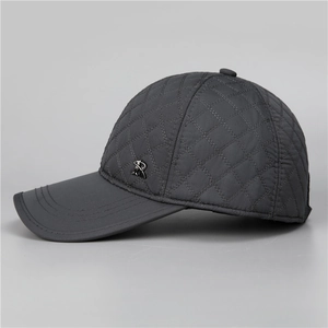 Detail of dark grey quilted baseball cap with diamond pattern and metal R logo