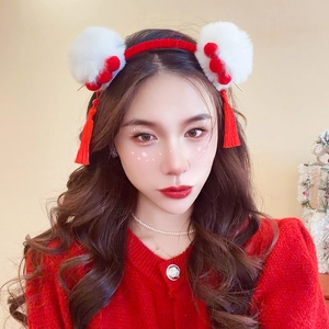 Detail of red tassel and white faux fur balls on a festive Chinese style headband