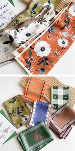 Detailed view of luxury silk scarves with vintage floral and geometric patterns