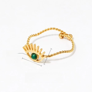 Detailed macro of golden evil eye ring with green natural stone and twisted band