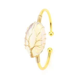 Close-up of wire-wrapped tree of life design on oval natural crystal cuff bracelet