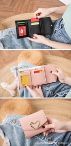 Detail view of tri-fold wallets with heart buckle, card slots and pebble leather texture