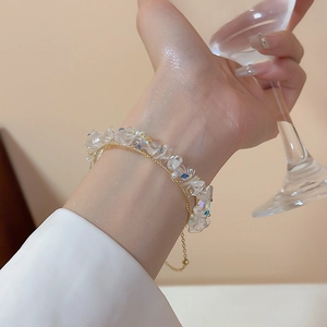 Dettaglio dell'elegante bracciale dorato a doppio strato con cristalli e tocchi blu