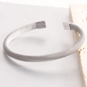 Detail shot of 7mm silver mesh cuff bracelet with polished ends on stone background